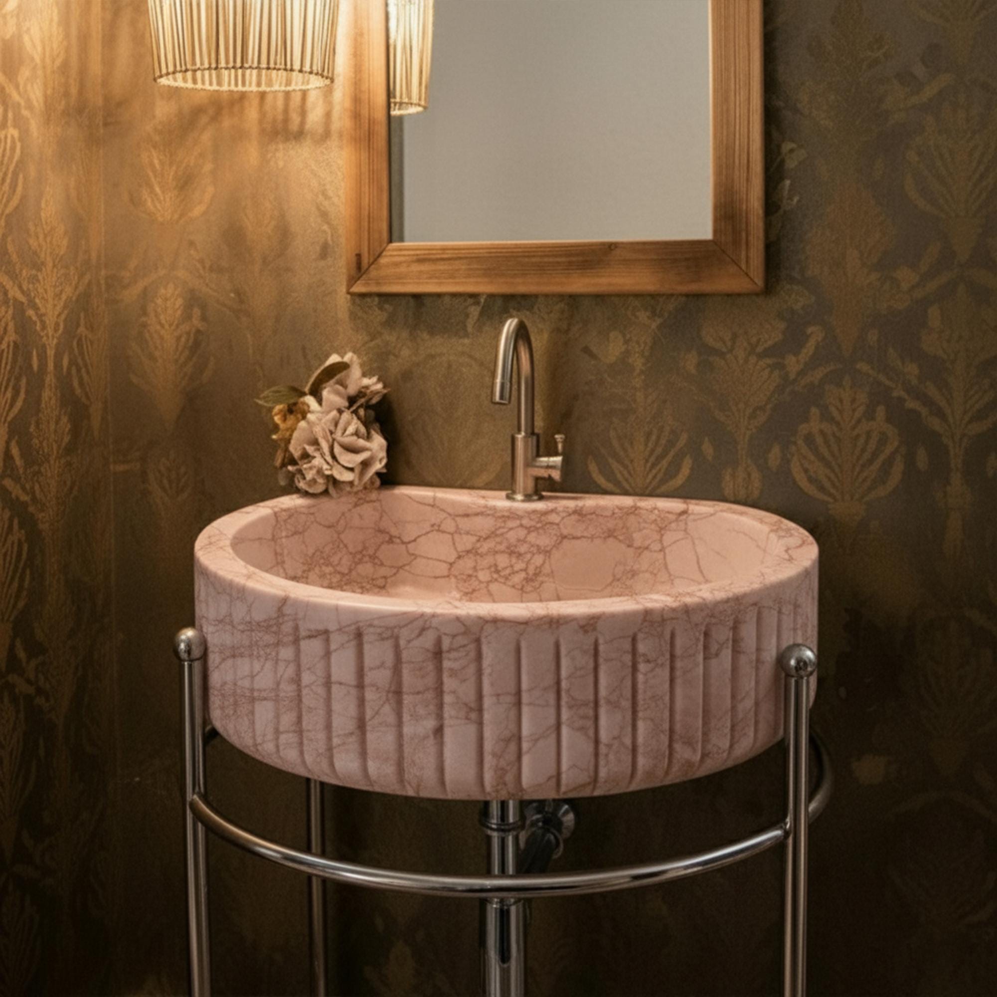 A sculpted pink marble vessel sink with delicate veining adds refined beauty and soft luxury to a compact yet elegant bathroom space.